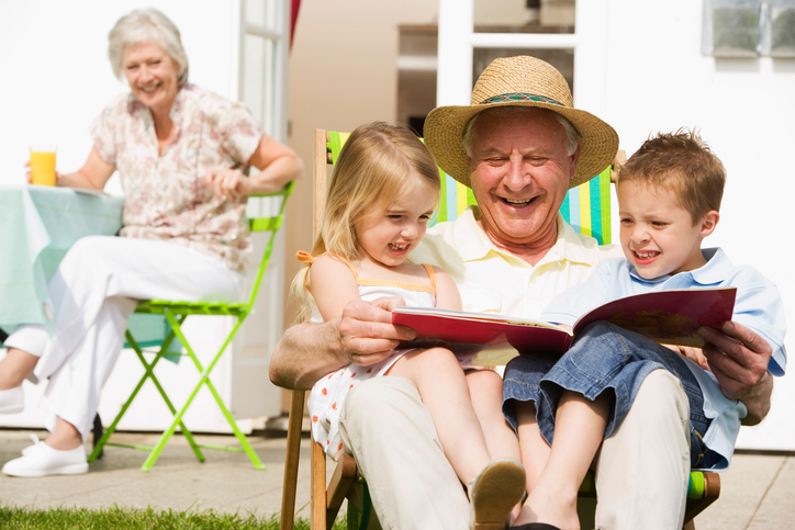 Grandfather reading to grandchildren